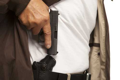 Man drawing pistol from concealed holster